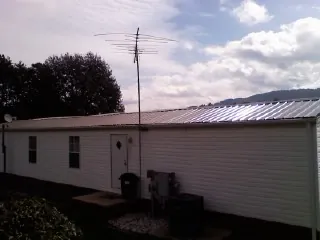 New metal roof on a single wide mobile home with a TV antenna in Hillsborough